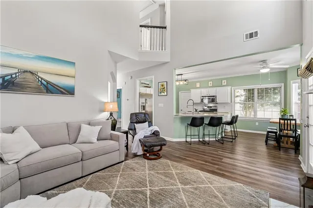 a living room with furniture a large window and wooden floor