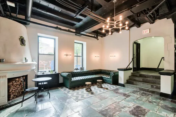 a living room with furniture a fireplace and a chandelier