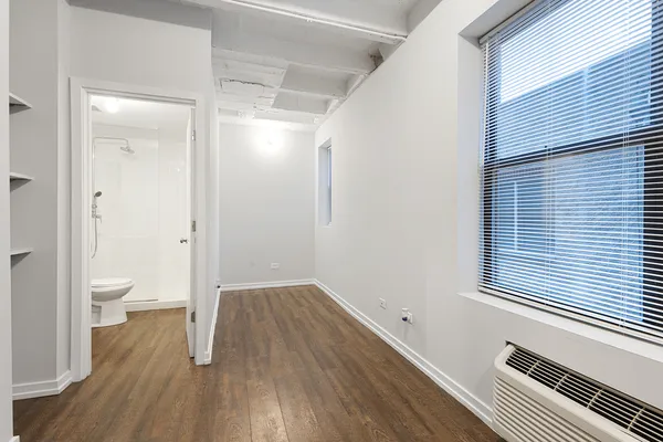 a view of a room with wooden floor and a toilet