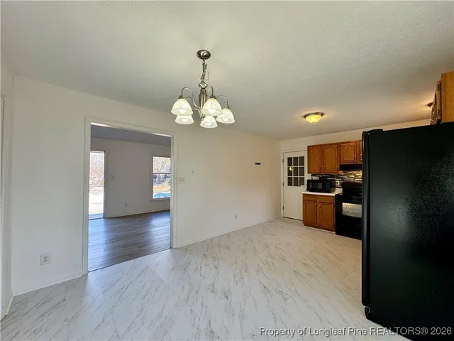 a view of kitchen with refrigerator and cabinets