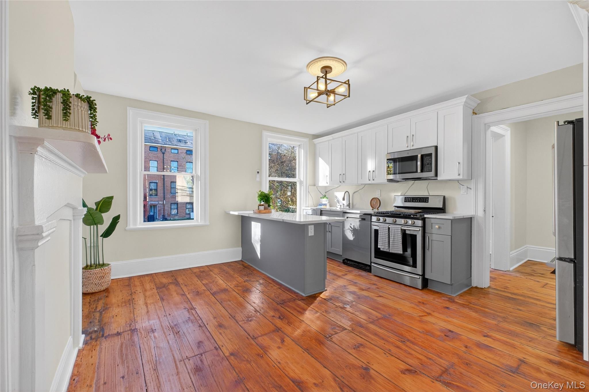 171 Chambers Street, Unit A Newburgh, NY 12550 - Photo 13 of 27 a kitchen with a wooden floor stainless steel appliances and window