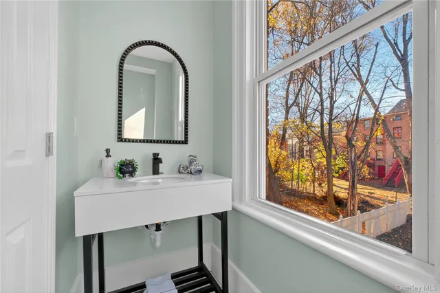 a bathroom with a sink a mirror and a window