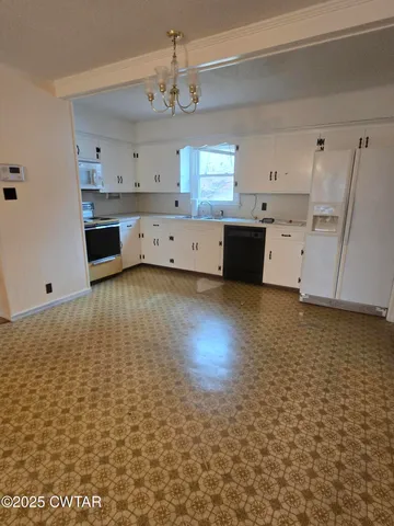 a view of a livingroom with a chair and a chandelier
