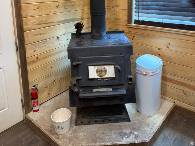 785 Hardscrabble Road Morgan, UT 84050 - Photo 13 of 16 Black wood-burning stove with a metal flue pipe, set on a raised hearth with tile flooring