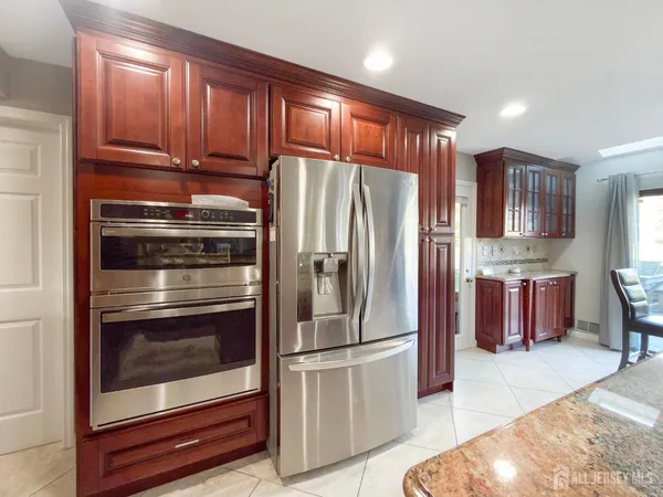 a metallic refrigerator freezer sitting inside of a kitchen
