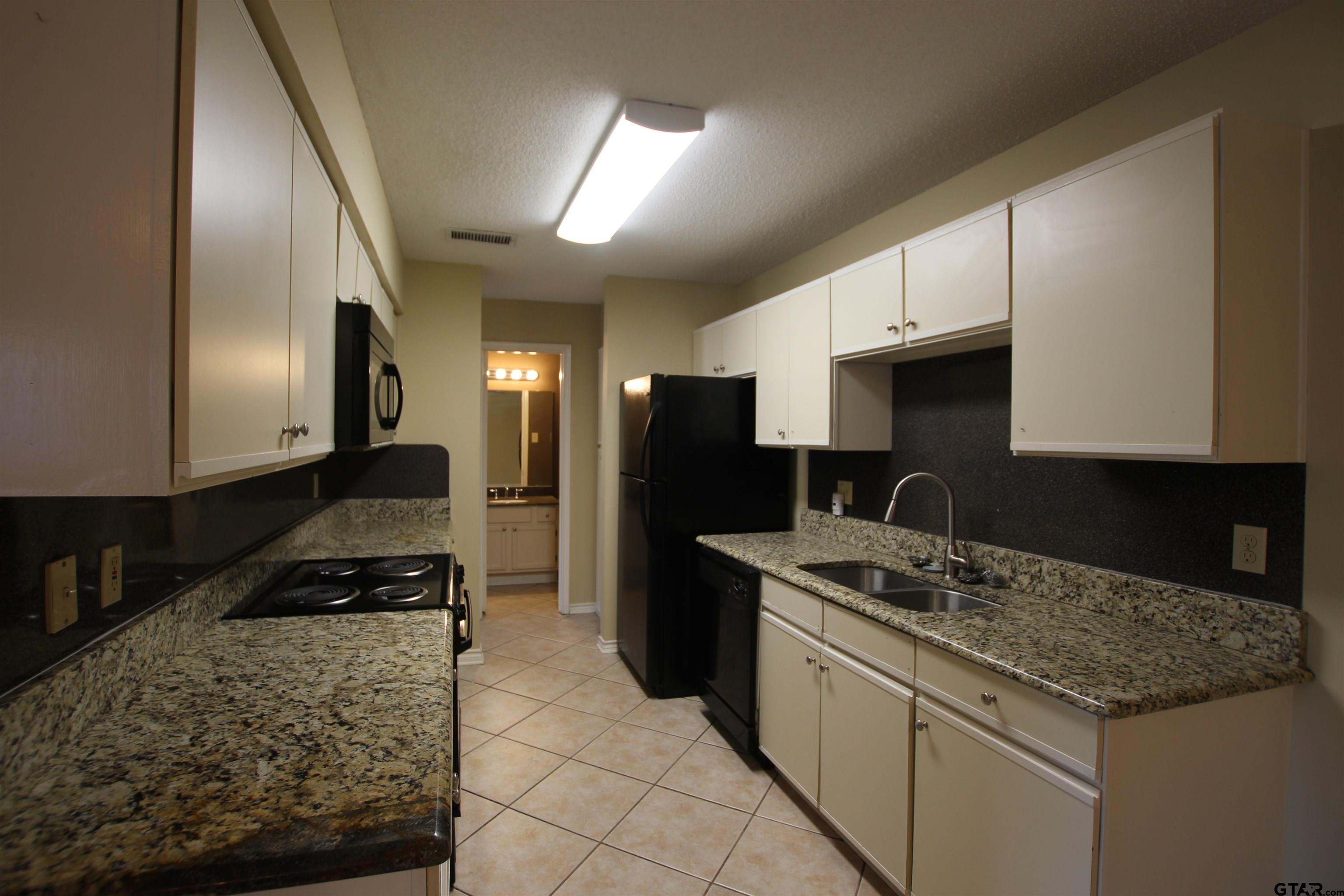 5875 Creekside Circle Tyler, TX 75703 - Photo 12 of 32 a kitchen with a sink stove and refrigerator
