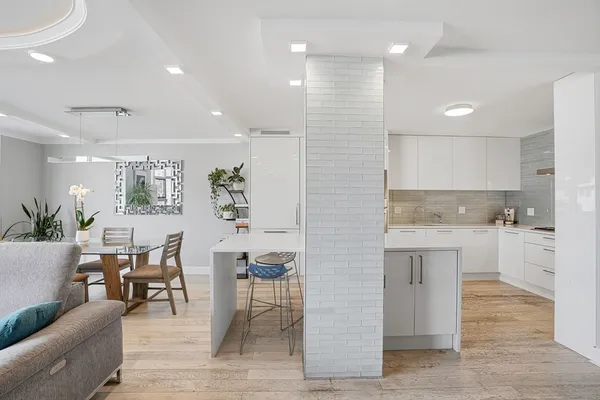a large white kitchen with lots of white furniture a sink and appliances