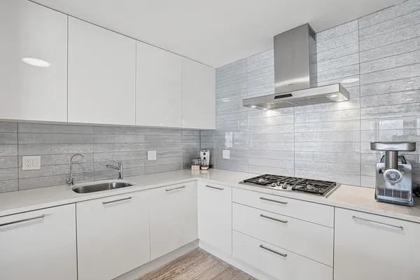 a kitchen with sink a stove and cabinets