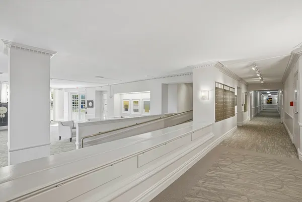 a view of a hallway with wooden floor and a living room