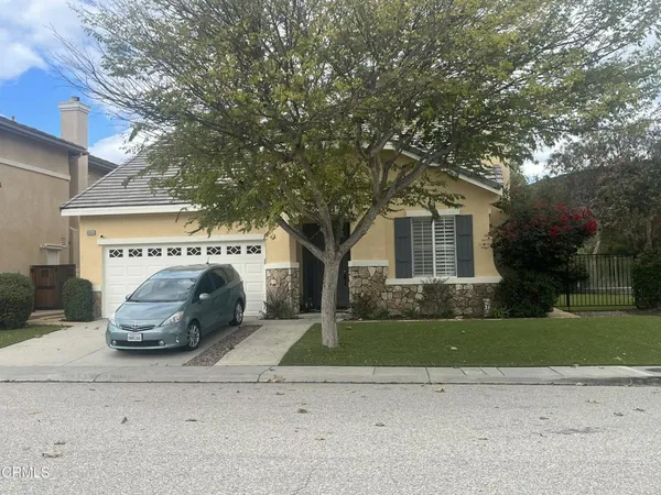 a white house that has a tree in front of it