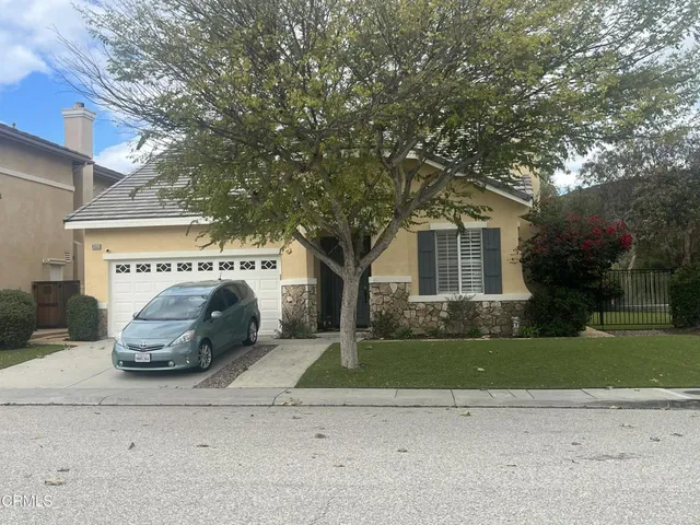 a white house that has a tree in front of it
