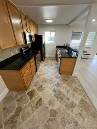 a kitchen with stainless steel appliances kitchen island granite countertop a refrigerator and a sink