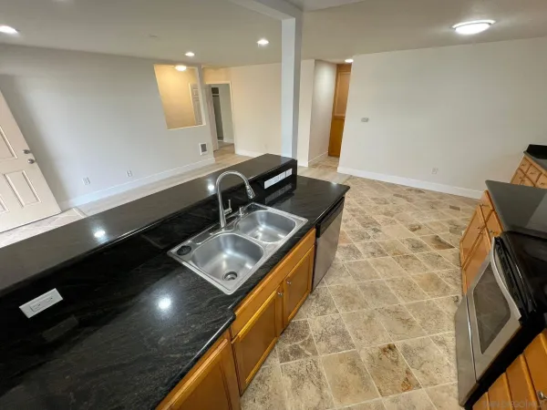 a kitchen with a sink a counter top space and a stove top oven