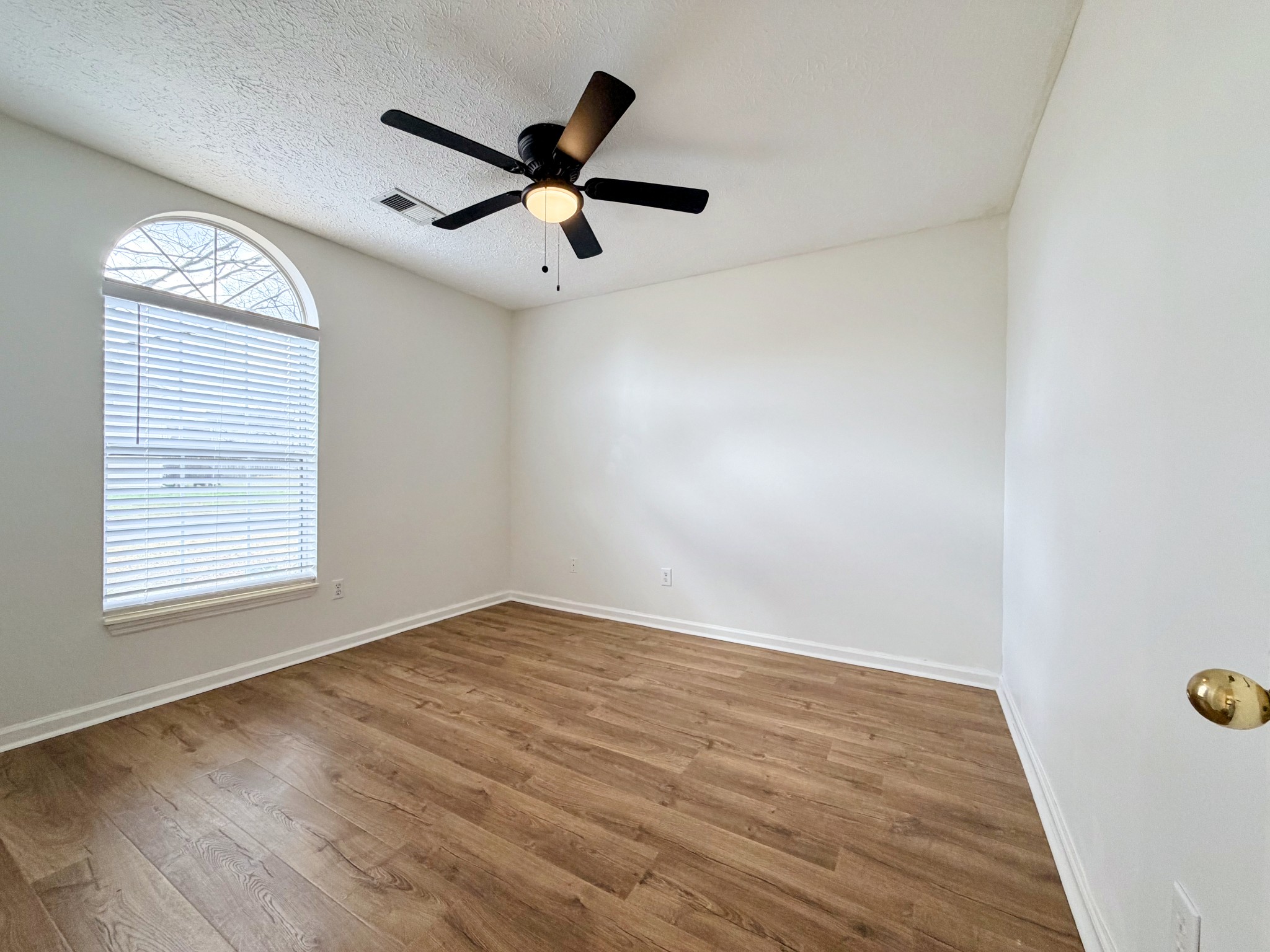 2544 Johnson Ridge Road Antioch, TN 37013 - Photo 12 of 30 an empty room with wooden floor fan and windows