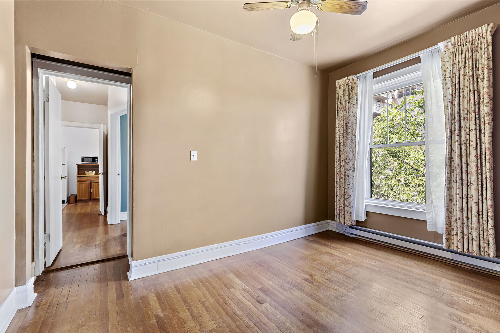 6255 North Sheridan Road, Unit 36 Chicago, IL 60660 - Photo 15 of 25 a view of an empty room with wooden floor and a window