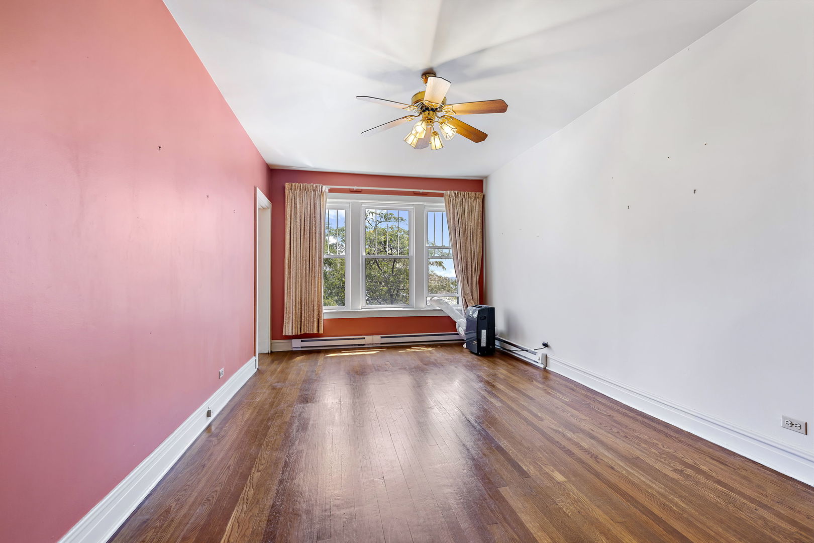 6255 North Sheridan Road, Unit 36 Chicago, IL 60660 - Photo 5 of 25 a view of an empty room with a window and wooden floor