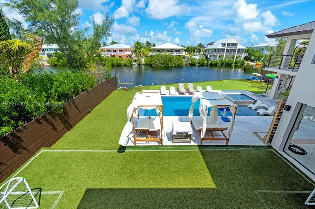 an aerial view of a house with swimming pool patio and lake view