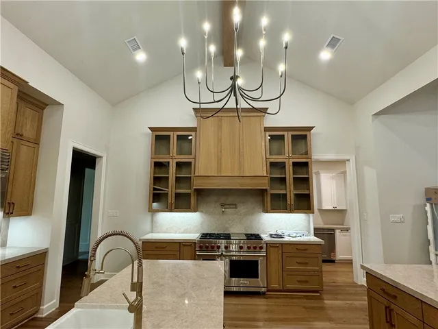 an empty room with wooden floor a ceiling fan a fireplace and windows