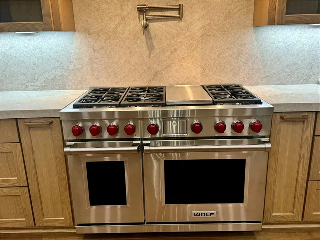 a view of an empty room with wooden floor fireplace and a window