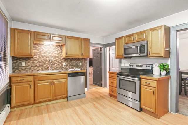 a kitchen with stainless steel appliances granite countertop a stove a sink and a microwave