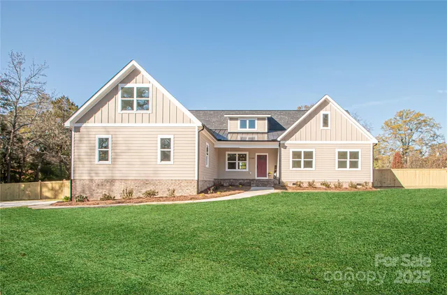 a front view of a house with a yard and trees