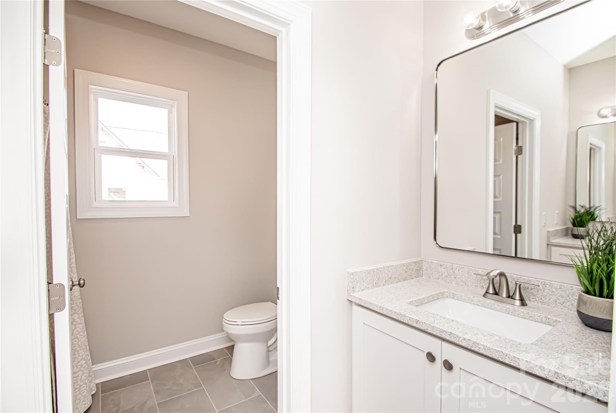 1508 Marion Street Monroe, NC 28112 - Photo 33 of 48 a bathroom with a granite countertop sink toilet and mirror