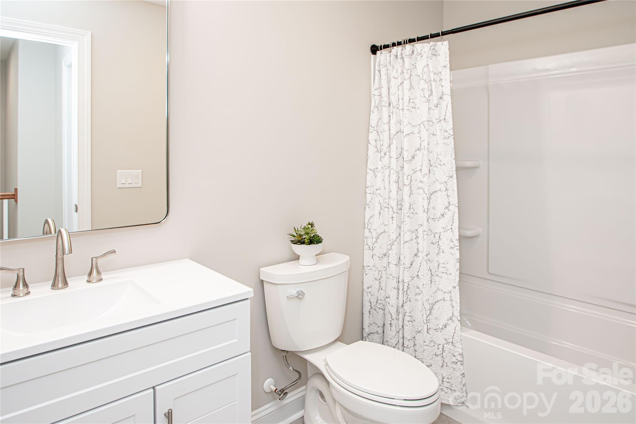 1508 Marion Street Monroe, NC 28112 - Photo 39 of 48 a bathroom with a sink a toilet a mirror and shower curtain
