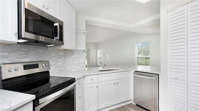 a kitchen with stainless steel appliances a stove microwave and sink