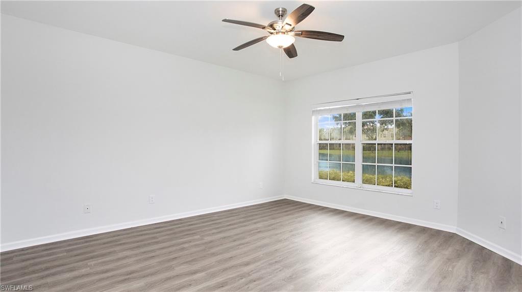 6225 Bellerive Avenue, Unit 1501 Naples, FL 34119 - Photo 16 of 22 an empty room with wooden floor and windows