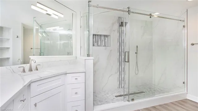 a bathroom with a shower sink and mirror