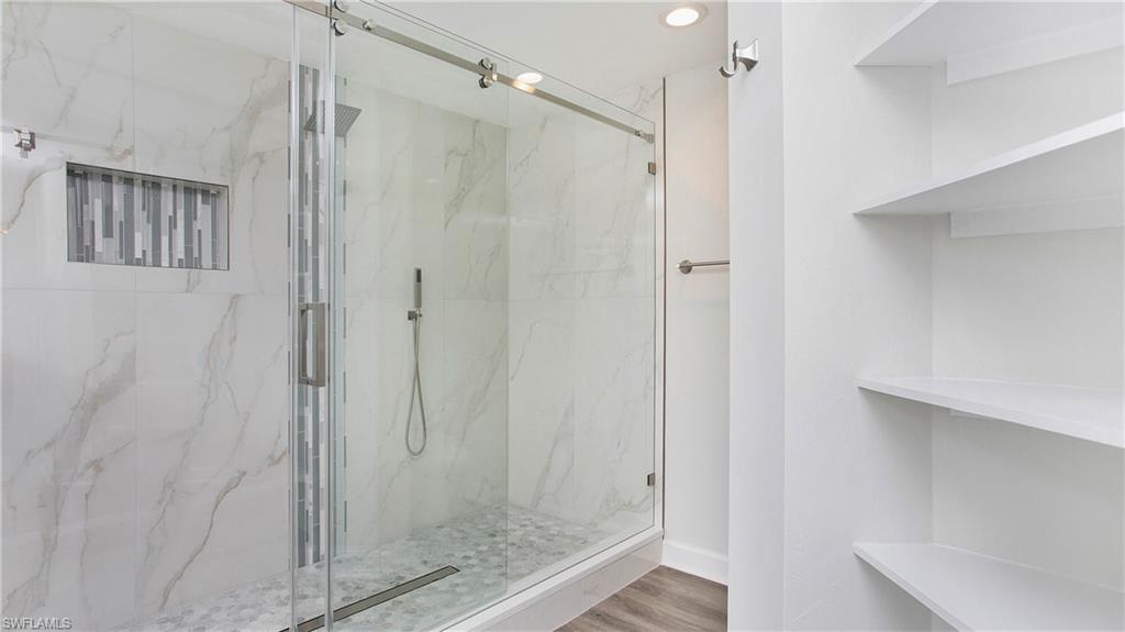 6225 Bellerive Avenue, Unit 1501 Naples, FL 34119 - Photo 21 of 22 a bathroom with a glass shower door