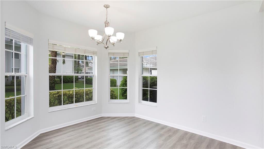 6225 Bellerive Avenue, Unit 1501 Naples, FL 34119 - Photo 6 of 22 a view of an empty room with a window and wooden floor