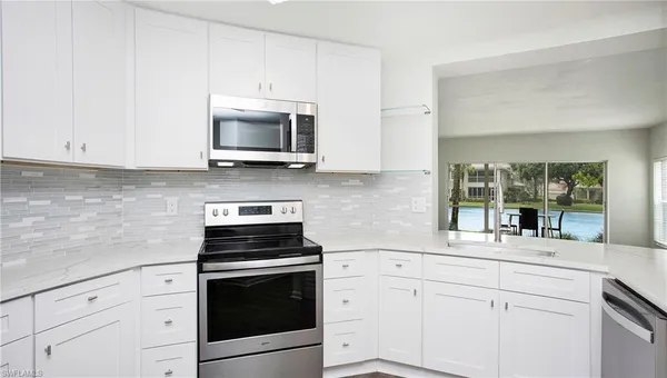 a kitchen with stainless steel appliances white cabinets and a stove a sink