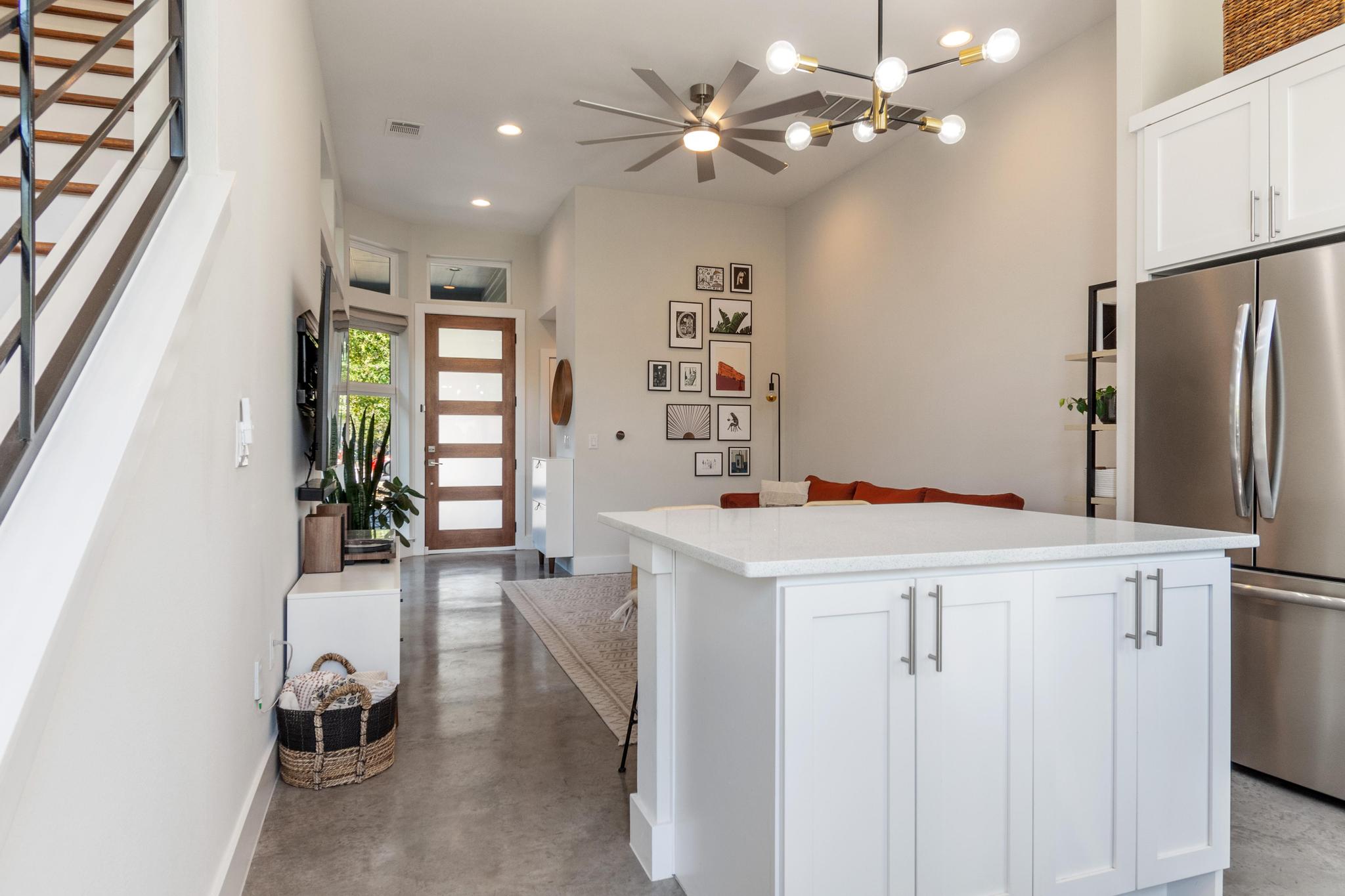 1177 Pandora Street, Unit B Austin, TX 78702 - Photo 2 of 30 Kitchen with white cabinetry, freestanding refrigerator, concrete floors, a kitchen island, and a breakfast bar area
