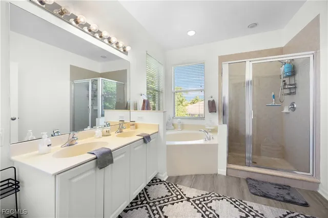 a large bathroom with a double vanity sink a mirror and a bathtub