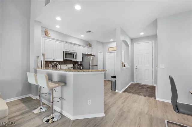 a kitchen with stainless steel appliances granite countertop a refrigerator and a stove top oven