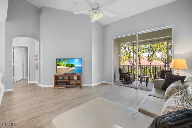 a living room with furniture a window and a flat screen tv