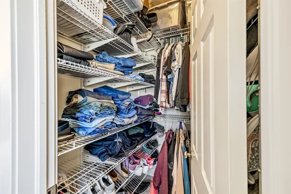 a view of walk in closet with clothes and shoes