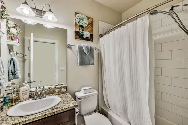 a bathroom with a sink vanity mirror and toilet
