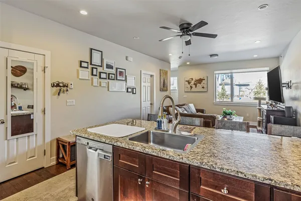 a kitchen with granite countertop a sink a counter top space and stainless steel appliances