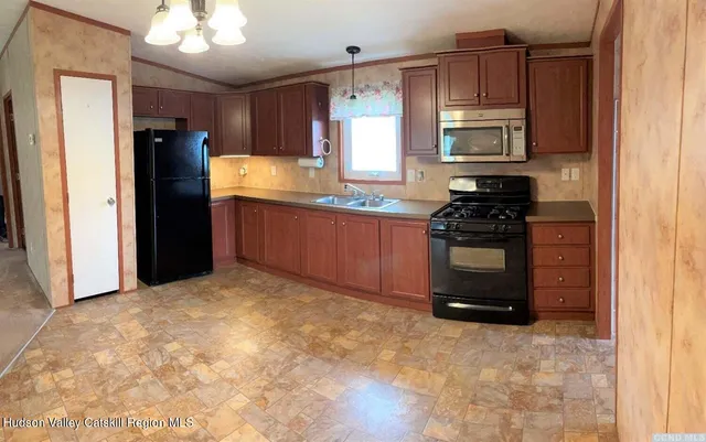 a kitchen with stainless steel appliances granite countertop a stove a refrigerator and a sink