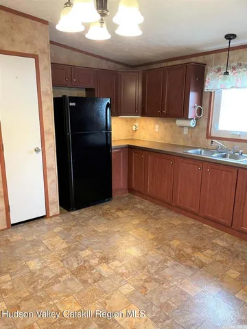 a kitchen with granite countertop a refrigerator and a sink