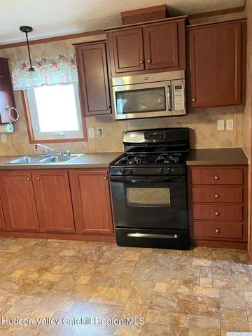 a kitchen with stainless steel appliances granite countertop a stove microwave and cabinets