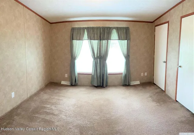 an empty room with large window and a door