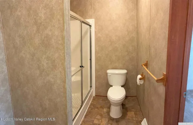 a bathroom with a toilet and a shower