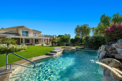 a view of a house with a backyard and sitting area