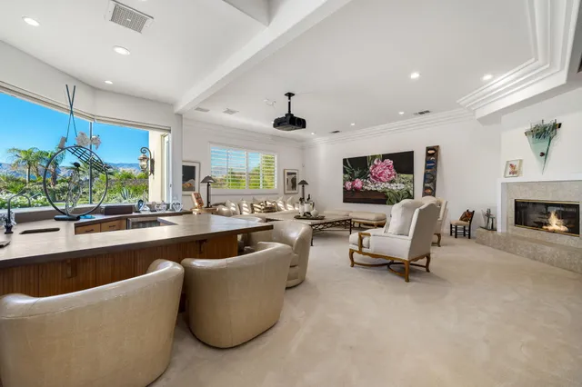 a large living room with stainless steel appliances kitchen island granite countertop furniture and a large window