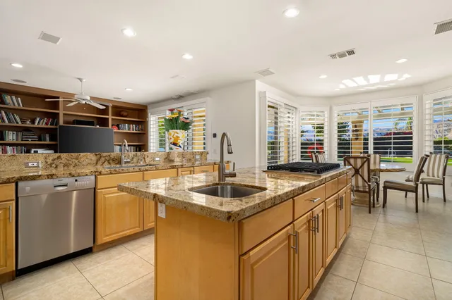 a large kitchen with stainless steel appliances granite countertop a stove a sink dishwasher and a refrigerator