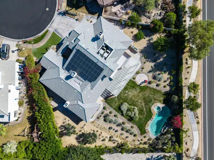 an aerial view of a house with a yard and large trees