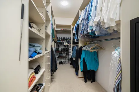 a spacious bedroom with a bed and a tv